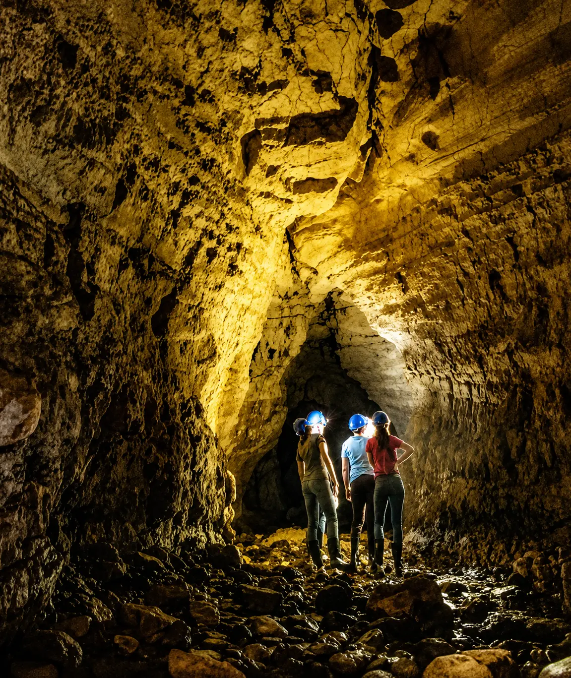 Four explorers in helmets inside the Venado Caves, Costa Rica